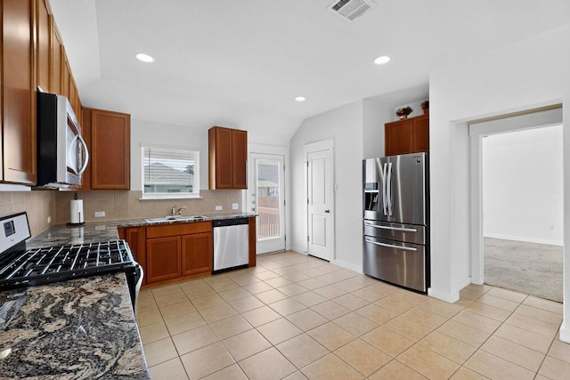 7619 Europa Ave, Round Rock, TX 78665 - kitchen featuring stainless steel appliances, tasteful backsplash, light tile patterned flooring, recessed lighting, and dark stone countertops