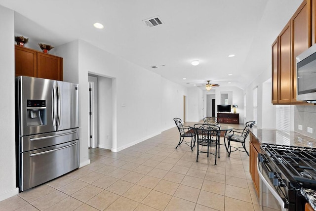 7619 Europa Ave, Round Rock, TX 78665 - kitchen featuring stainless steel appliances, brown cabinetry, light tile patterned floors, a ceiling fan, and tasteful backsplash