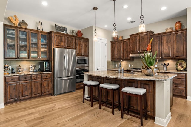 9 Borello Dr Unit 9, Austin, TX 78738 - kitchen with stainless steel appliances, decorative backsplash, dark brown cabinets, light wood finished floors, and recessed lighting