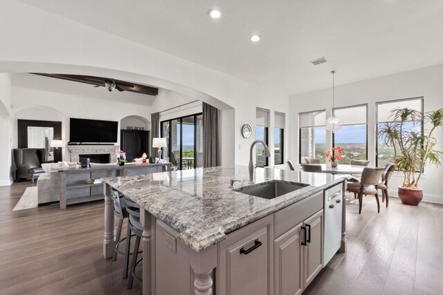 1300 Sparrow Ln, Austin, TX 78734 - kitchen with recessed lighting, an island with sink, ceiling fan, light stone countertops, and arched walkways