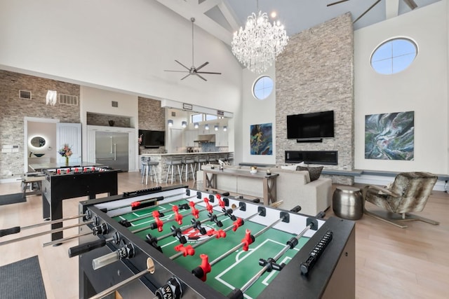 1300 Sparrow Ln, Austin, TX 78734 - game room featuring high vaulted ceiling, wood finished floors, ceiling fan, a chandelier, and a fireplace