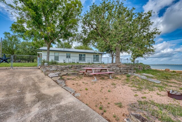 106 Chuckwagon, Burnet, TX 78611 - view of front of property with a gate, a water view, and a metal roof