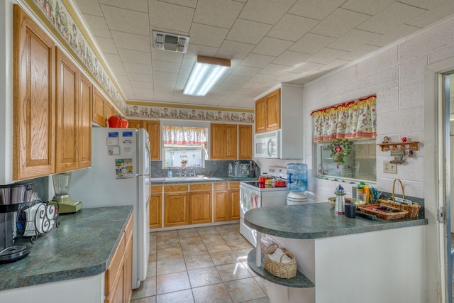 106 Chuckwagon, Burnet, TX 78611 - kitchen with white appliances, open shelves, ornamental molding, dark countertops, and brown cabinetry