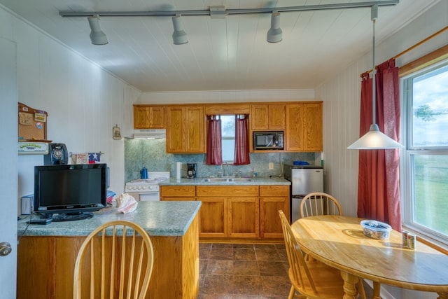 106 Chuckwagon, Burnet, TX 78611 - kitchen featuring black microwave, rail lighting, brown cabinets, and healthy amount of natural light