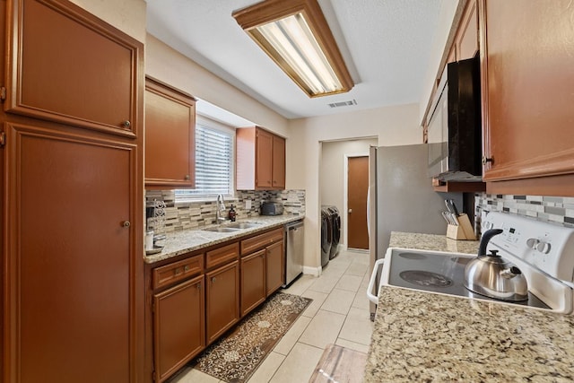1602 Plateau Rdg, Cedar Park, TX 78613 - kitchen featuring stainless steel appliances, backsplash, brown cabinetry, and light tile patterned floors