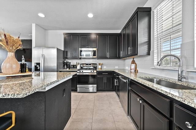 244 Fabion St, Kyle, TX 78640 - kitchen featuring stainless steel appliances, light stone counters, tasteful backsplash, dark cabinets, and recessed lighting
