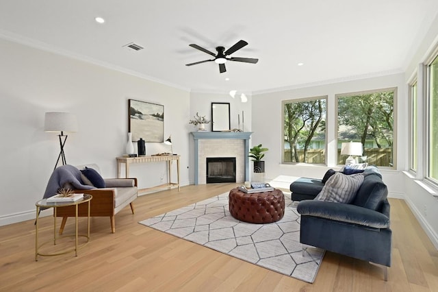 8902 Rustic Cv, Austin, TX 78717 - living room with light wood finished floors, a fireplace, crown molding, a ceiling fan, and recessed lighting