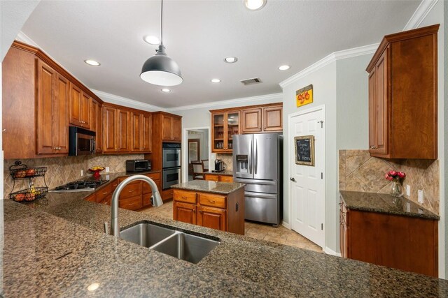 2500 Melekhin Bnd, Cedar Park, TX 78613 - kitchen with stainless steel appliances, crown molding, recessed lighting, dark stone countertops, and brown cabinets
