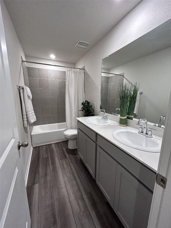 11503 Copperstone Ave Unit 89, Austin, TX 78748 - full bathroom featuring wood finished floors, double vanity, shower / bath combination with curtain, and recessed lighting