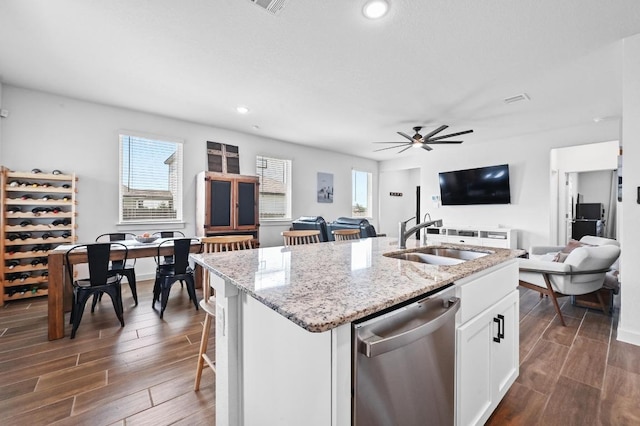 170 Banff Dr, Kyle, TX 78640 - kitchen with dishwasher, open floor plan, dark wood-type flooring, white cabinets, and a kitchen island with sink