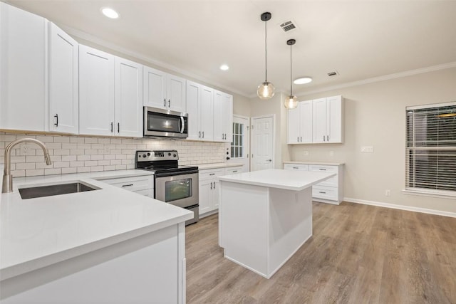 1113 Lott Ave, Austin, TX 78721 - kitchen with appliances with stainless steel finishes, crown molding, backsplash, light countertops, and white cabinets