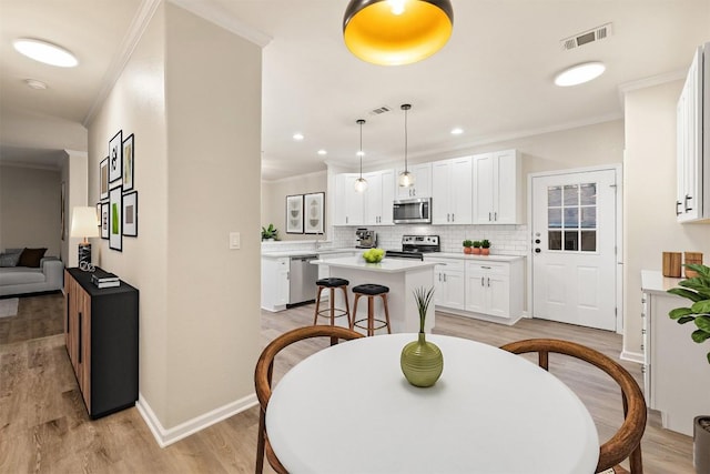 1113 Lott Ave, Austin, TX 78721 - dining space with crown molding, light wood-type flooring, and recessed lighting