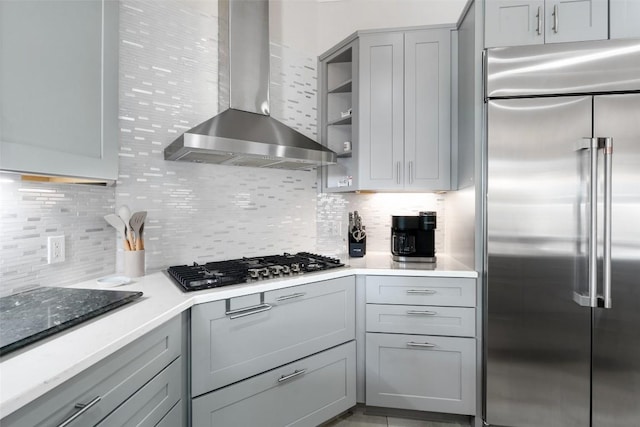 22126 Briarcliff Dr, Spicewood, TX 78669 - kitchen with appliances with stainless steel finishes, wall chimney range hood, gray cabinetry, and decorative backsplash