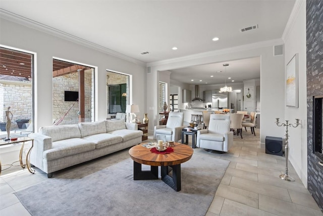 22126 Briarcliff Dr, Spicewood, TX 78669 - living room with crown molding, light tile patterned floors, a fireplace, a chandelier, and recessed lighting