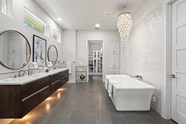 22126 Briarcliff Dr, Spicewood, TX 78669 - full bath with a soaking tub, double vanity, a chandelier, tile patterned floors, and a walk in closet