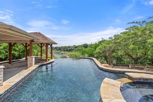 22126 Briarcliff Dr, Spicewood, TX 78669 - view of pool with an in-ground hot tub, an infinity pool, a patio area, and a water view