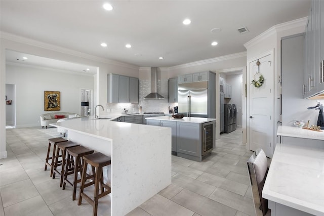 22126 Briarcliff Dr, Spicewood, TX 78669 - kitchen featuring gray cabinetry, built in fridge, wall chimney exhaust hood, beverage cooler, and recessed lighting