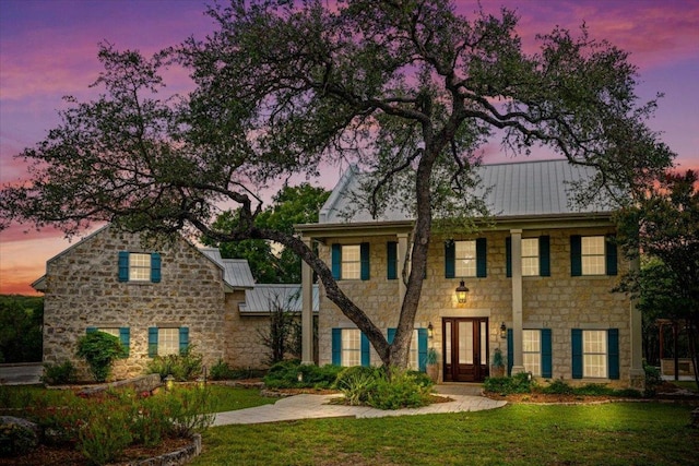 1660 W Mccarty Ln, San Marcos, TX 78666 - colonial house featuring stone siding, a standing seam roof, a lawn, and a metal roof