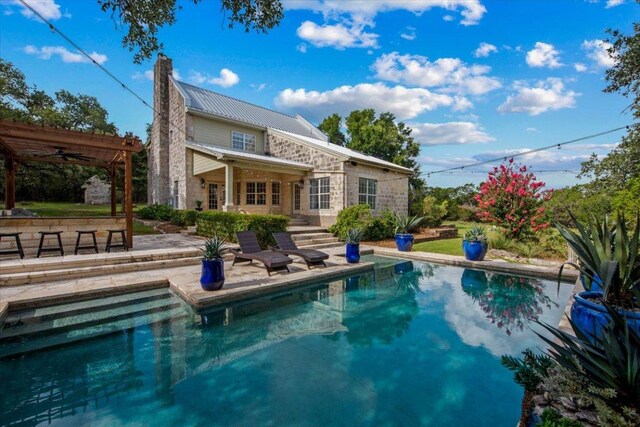 1660 W Mccarty Ln, San Marcos, TX 78666 - rear view of house with a patio, an outdoor pool, a chimney, and stone siding