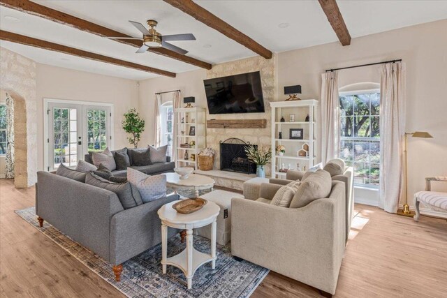 1660 W Mccarty Ln, San Marcos, TX 78666 - living room with wood finished floors, a high end fireplace, beamed ceiling, a ceiling fan, and french doors