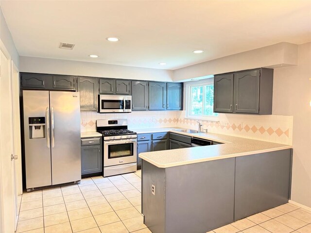 4202 Kilgore Ln, Austin, TX 78727 - kitchen featuring stainless steel appliances, a peninsula, light tile patterned flooring, light countertops, and gray cabinets