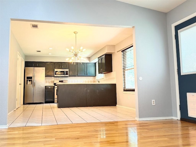 4202 Kilgore Ln, Austin, TX 78727 - kitchen with stainless steel appliances, a chandelier, backsplash, and light wood-type flooring