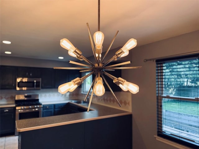 4202 Kilgore Ln, Austin, TX 78727 - kitchen view of stainless steel appliances, a chandelier, dark cabinetry, decorative light fixtures, and recessed lighting
