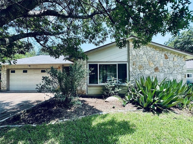 4202 Kilgore Ln, Austin, TX 78727 - view of front facade with stone siding, a garage, and driveway
