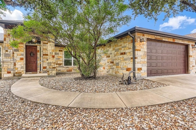 5501 Hitching Post, Lago Vista, TX 78645 - view of front of house with stone siding, an attached garage, and concrete driveway
