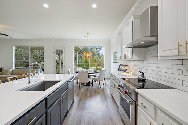 300 Errol Dr, Spicewood, TX 78669 - kitchen featuring appliances with stainless steel finishes, wall chimney exhaust hood, white cabinets, ornamental molding, and recessed lighting