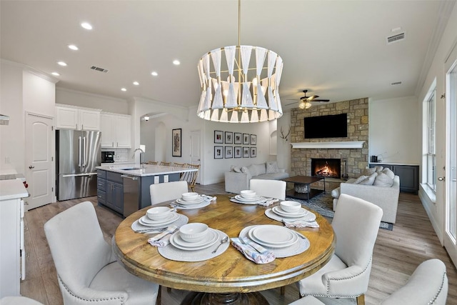 300 Errol Dr, Spicewood, TX 78669 - dining area featuring crown molding, ceiling fan, light wood finished floors, recessed lighting, and a fireplace