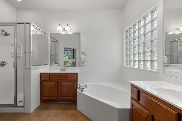300 Errol Dr, Spicewood, TX 78669 - full bathroom with a stall shower, a bath, two vanities, and tile patterned flooring