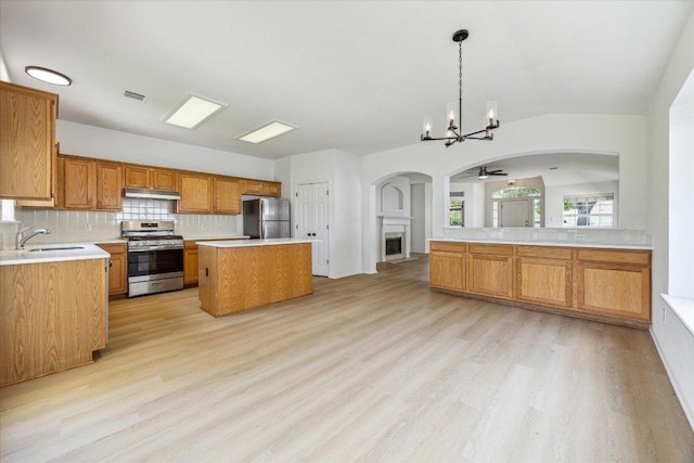 3659 Nolan Ryan Blvd, Round Rock, TX 78665 - kitchen featuring appliances with stainless steel finishes, arched walkways, under cabinet range hood, a center island, and a chandelier