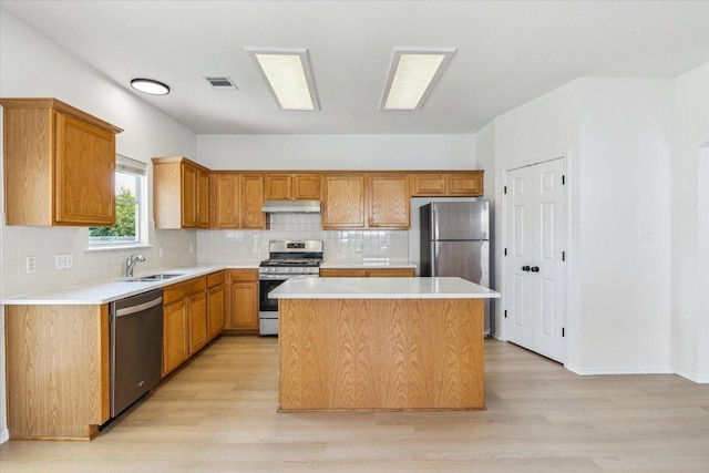 3659 Nolan Ryan Blvd, Round Rock, TX 78665 - kitchen with stainless steel appliances, range hood, light wood-type flooring, a center island, and light countertops