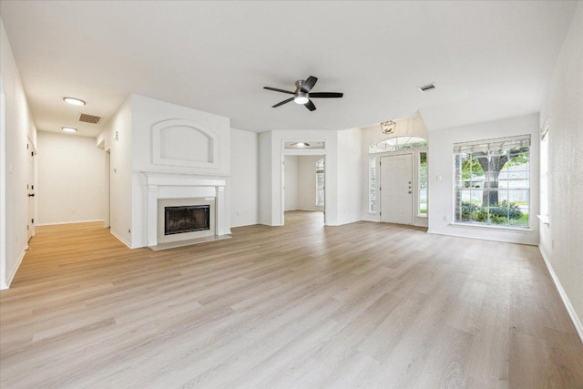 3659 Nolan Ryan Blvd, Round Rock, TX 78665 - unfurnished living room with light wood-style flooring, a fireplace with flush hearth, and a ceiling fan
