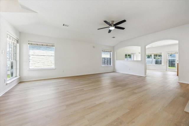 3659 Nolan Ryan Blvd, Round Rock, TX 78665 - unfurnished living room featuring arched walkways, a ceiling fan, vaulted ceiling, plenty of natural light, and light wood-type flooring