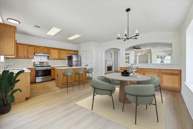 3659 Nolan Ryan Blvd, Round Rock, TX 78665 - dining area featuring arched walkways, a chandelier, light wood-type flooring, and ceiling fan