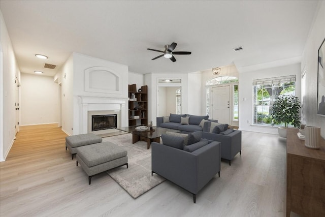 3659 Nolan Ryan Blvd, Round Rock, TX 78665 - living room featuring light wood finished floors, a fireplace, and a ceiling fan