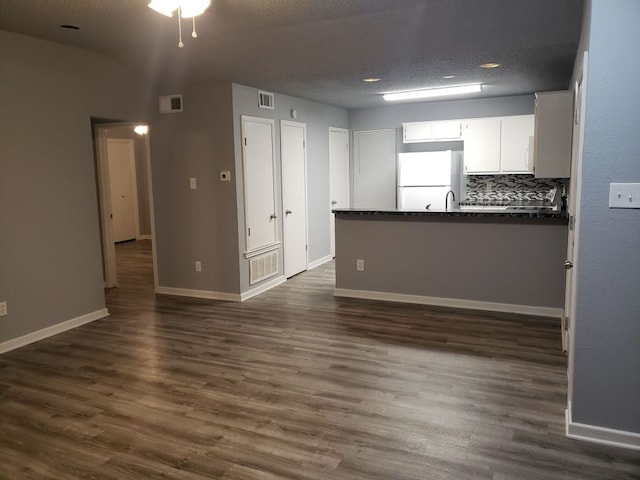 1221 W Hopkins St Unit 11, San Marcos, TX 78666 - unfurnished living room featuring dark wood-type flooring and a textured ceiling