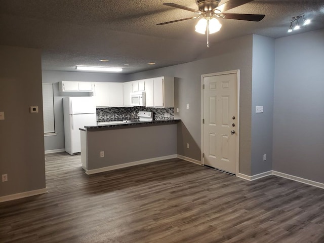 1221 W Hopkins St Unit 11, San Marcos, TX 78666 - kitchen featuring white appliances, dark countertops, a peninsula, dark wood-style flooring, and a ceiling fan