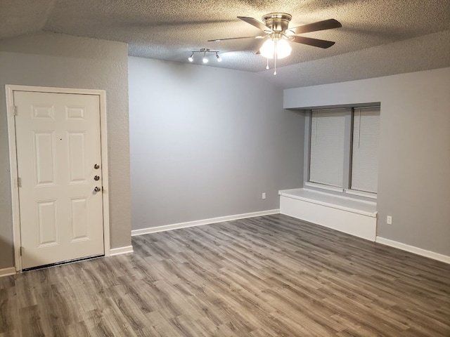 1221 W Hopkins St Unit 11, San Marcos, TX 78666 - empty room featuring vaulted ceiling, a ceiling fan, wood finished floors, and a textured ceiling