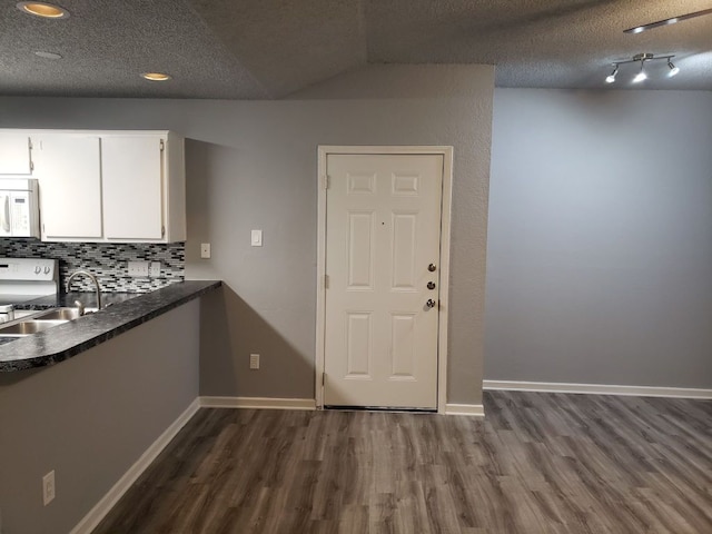 1221 W Hopkins St Unit 11, San Marcos, TX 78666 - kitchen with white microwave, dark wood finished floors, white cabinetry, backsplash, and a textured ceiling