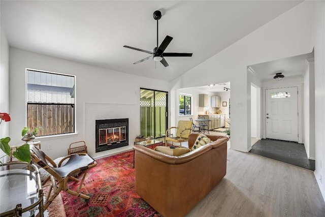 1406 Byers Ln, Austin, TX 78753 - living room with wood finished floors, a ceiling fan, a glass covered fireplace, and vaulted ceiling