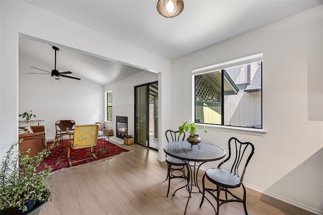 1406 Byers Ln, Austin, TX 78753 - dining space featuring healthy amount of natural light, wood finished floors, ceiling fan, lofted ceiling, and a glass covered fireplace