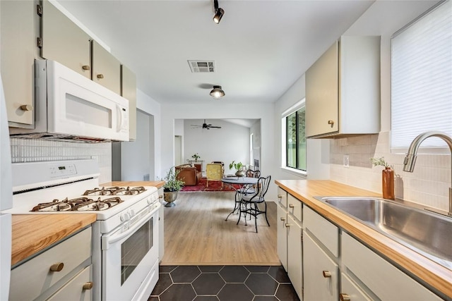 1406 Byers Ln, Austin, TX 78753 - kitchen with white appliances, dark tile patterned floors, ceiling fan, backsplash, and wooden counters