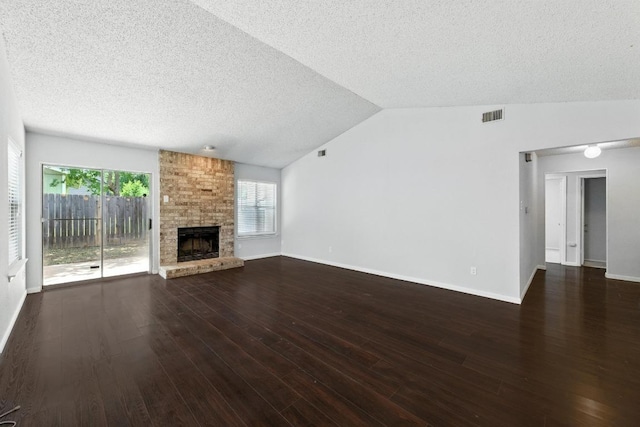 4614 Ganymede Dr, Austin, TX 78727 - unfurnished living room with a textured ceiling, a large fireplace, dark wood finished floors, and vaulted ceiling