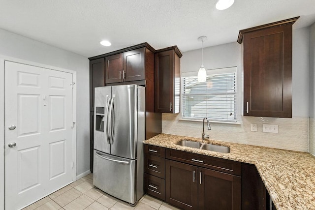 4614 Ganymede Dr, Austin, TX 78727 - kitchen featuring stainless steel fridge, dark brown cabinets, decorative backsplash, light stone countertops, and pendant lighting