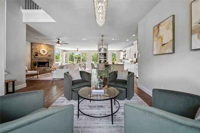 1621 Angolo, New Braunfels, TX 78132 - living room featuring a stone fireplace, dark wood-type flooring, ceiling fan, a chandelier, and recessed lighting