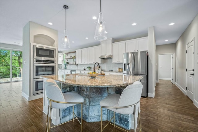 1621 Angolo, New Braunfels, TX 78132 - kitchen with stainless steel appliances, white cabinets, under cabinet range hood, backsplash, and recessed lighting