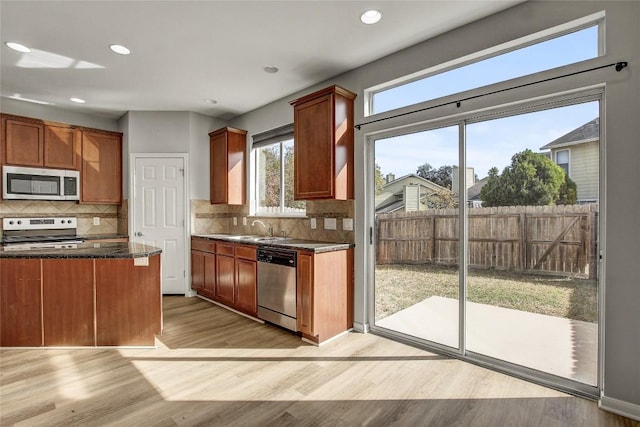 512 Eberhart Ln Unit 1207, Austin, TX 78745 - kitchen with stainless steel appliances, light wood-style flooring, tasteful backsplash, recessed lighting, and brown cabinetry